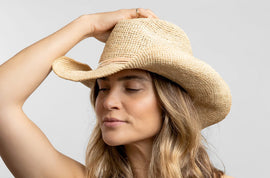 Woman wearing sun hat made of raffia material.