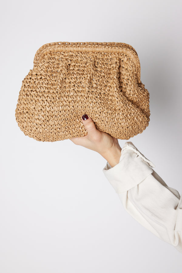brown straw slouchy bag in model's hand