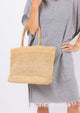 Model holding raffia straw tote
