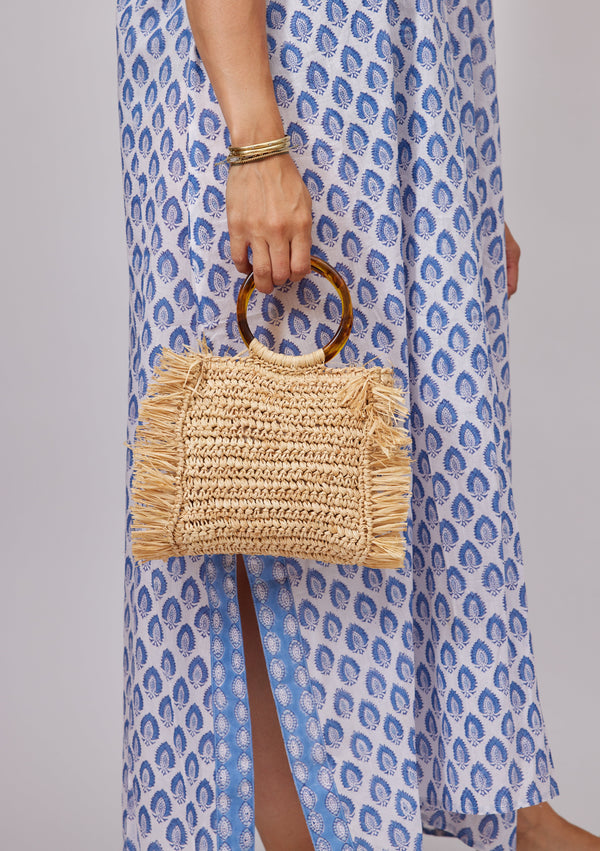 Model holding straw bag with round tortoise handles