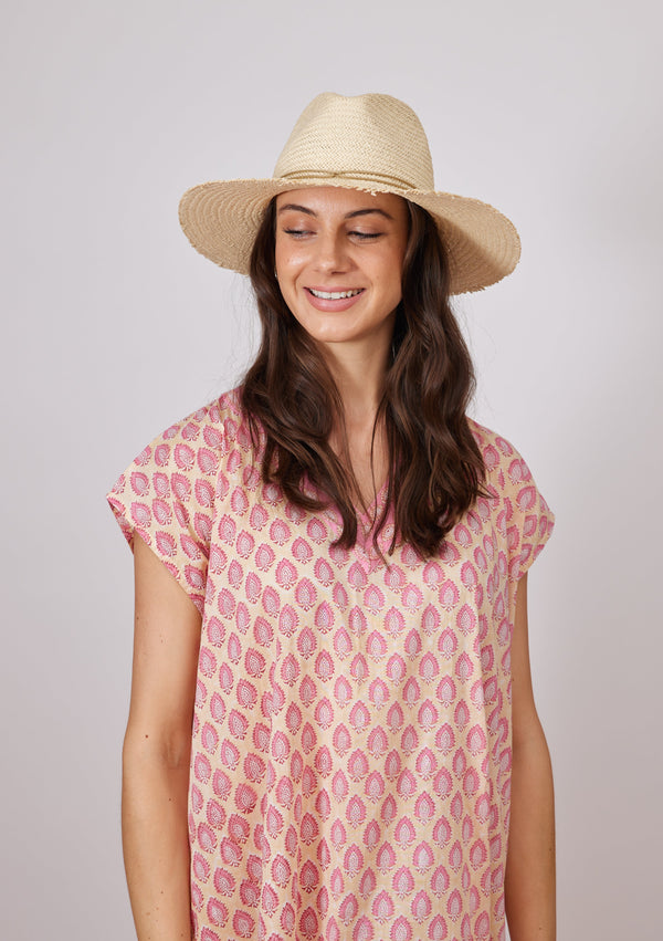Model looking down wearing fringed sun hat