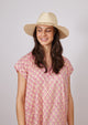 Model looking down wearing fringed sun hat