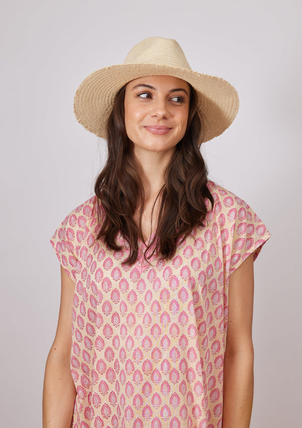 Model looking to her left wearing fringed straw hat