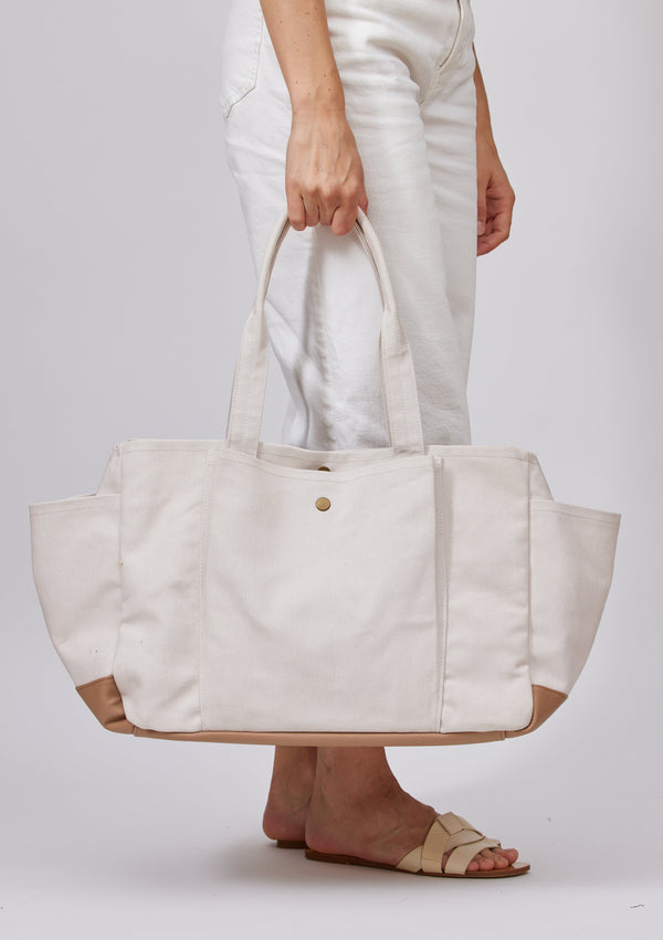 Model holding white tote with pockets