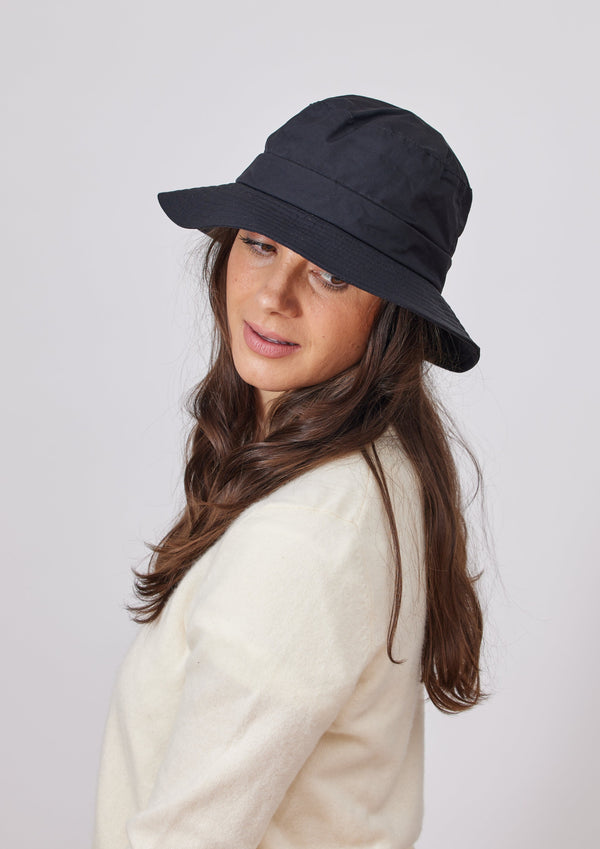 Model wearing black water resistant bucket hat