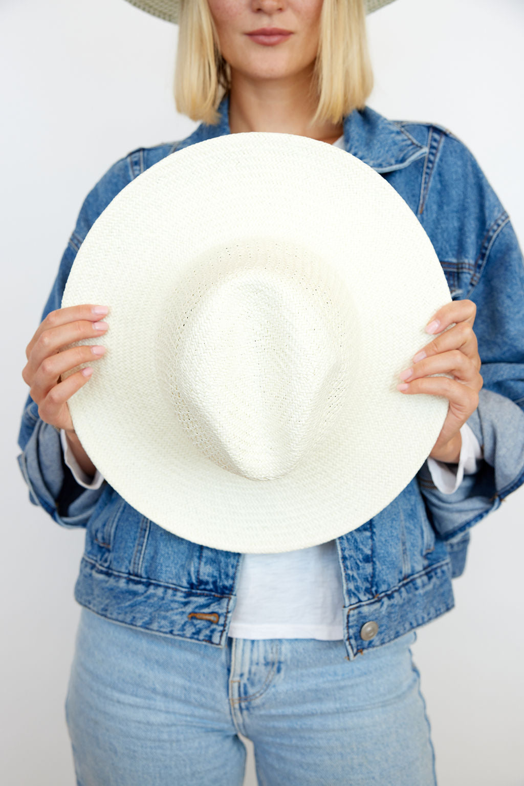 Model holding perforated and vented packable hat in bleach on model
