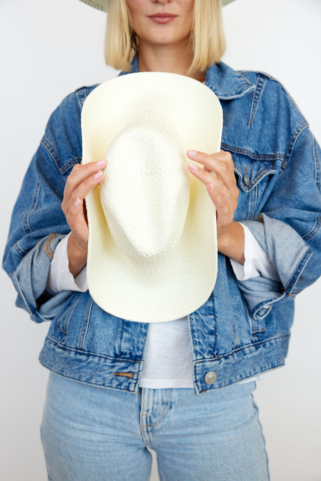 Model holding perforated and vented packable hat in bleach and showing its packable