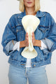 Model folding perforated and vented packable hat in bleach and showing its packable