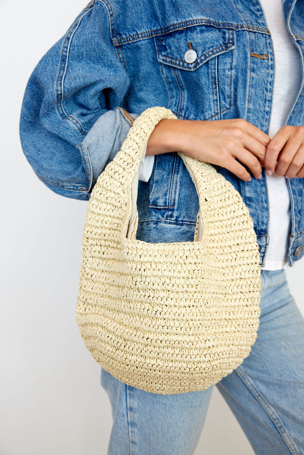 Close up of model wearing paper straw slouchy bag