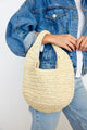 Close up of model wearing paper straw slouchy bag