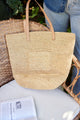 Straw tote sitting in chair with a book