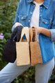 model holding natural, brown and black small straw totes