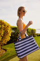 Model holding blue and lavender striped bag