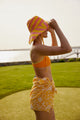 Model wearing coral and yellow striped bucket hat