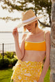 Model wearing straw hat with white trim