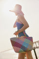 Molding holding brim of pink sunhat and colorful tote