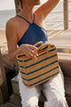 Model holding blue striped tote