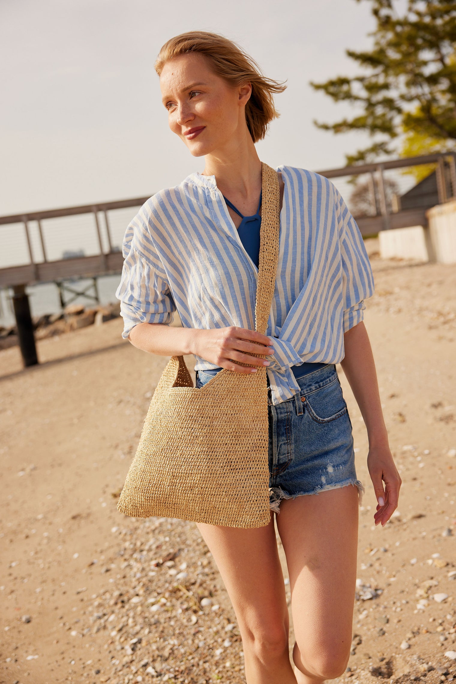 Model wearing straw crossbody bag