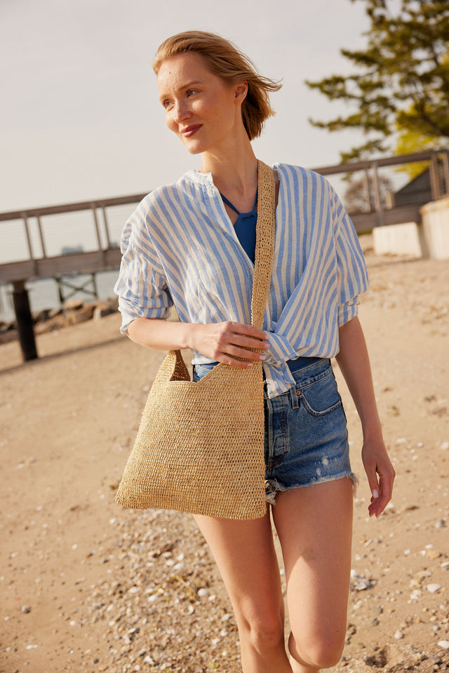 Model wearing straw crossbody bag