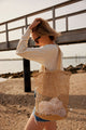 Model wearing natural straw fisherman bag