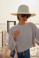 Model wearing green and white sunhat and straw cooler tote