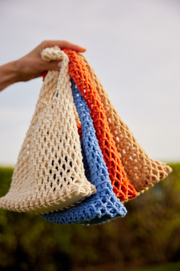 Model holding 4 colorful cotton bags