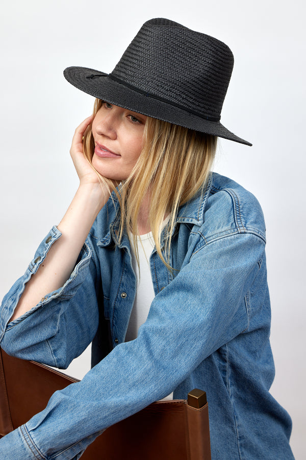 Model wearing black straw fedora and denim shirt