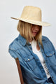 Model wearing tan and white woven sun hat and denim shirt