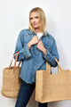 Model holding natural woven structured tote with handles