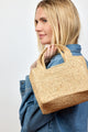 Model holding small structured woven straw bag