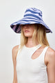 Model wearing blue and lavender bucket hat and white tank top
