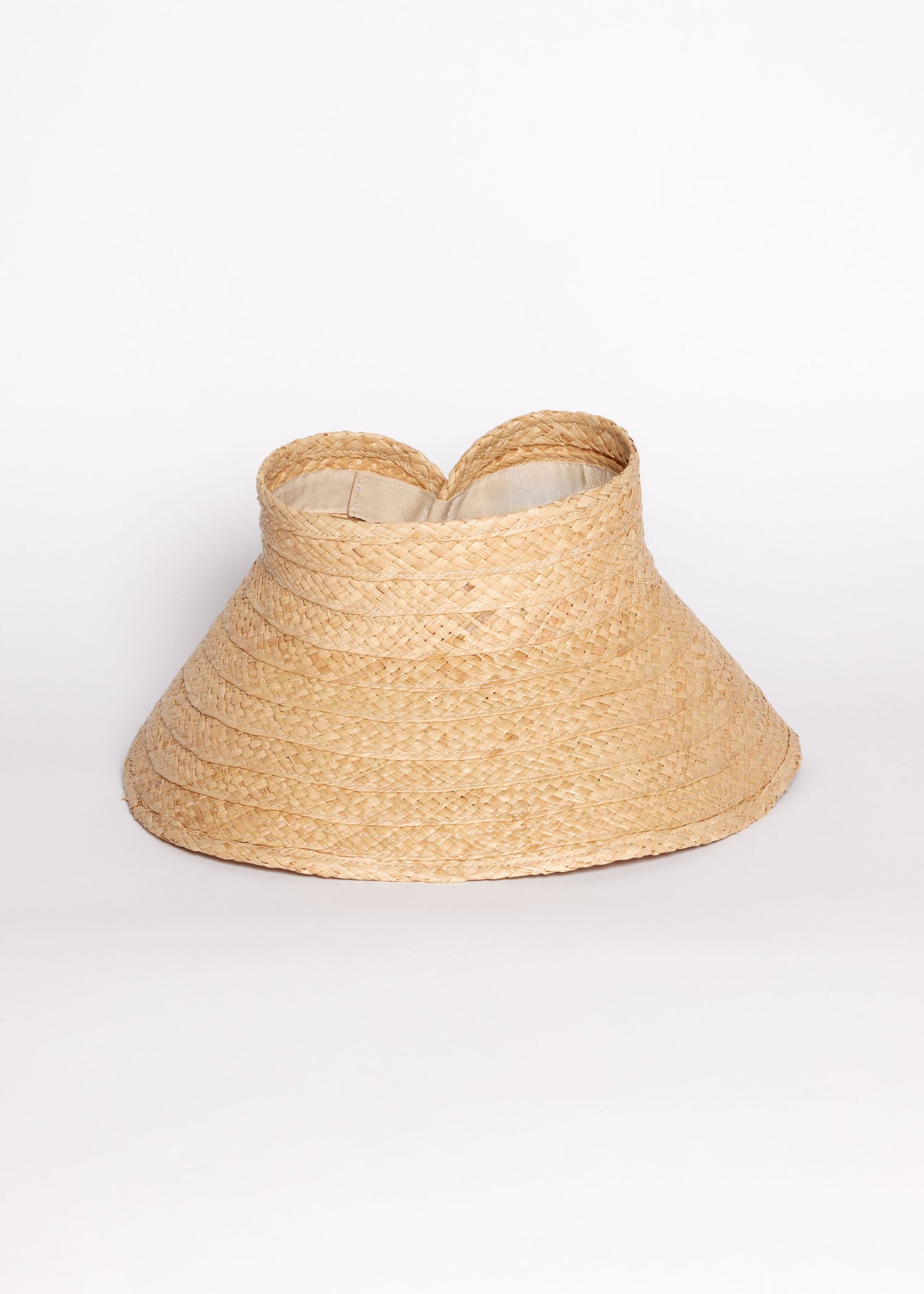 Beige straw visor hat on a white background