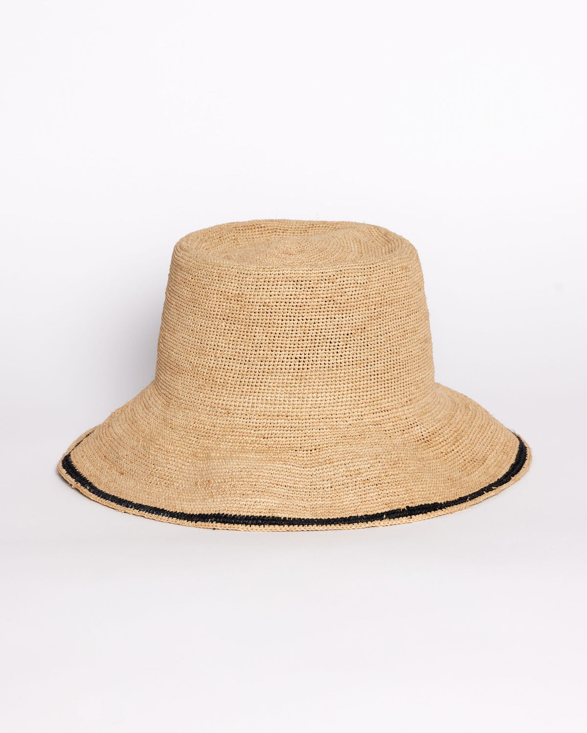 Beige straw bucket hat with black trim on a white background