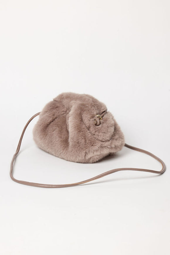 3/4 angle of taupe faux fur clutch with strap