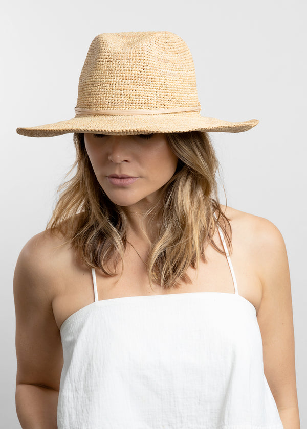 Model wearing crochet sunhat with tan wrap