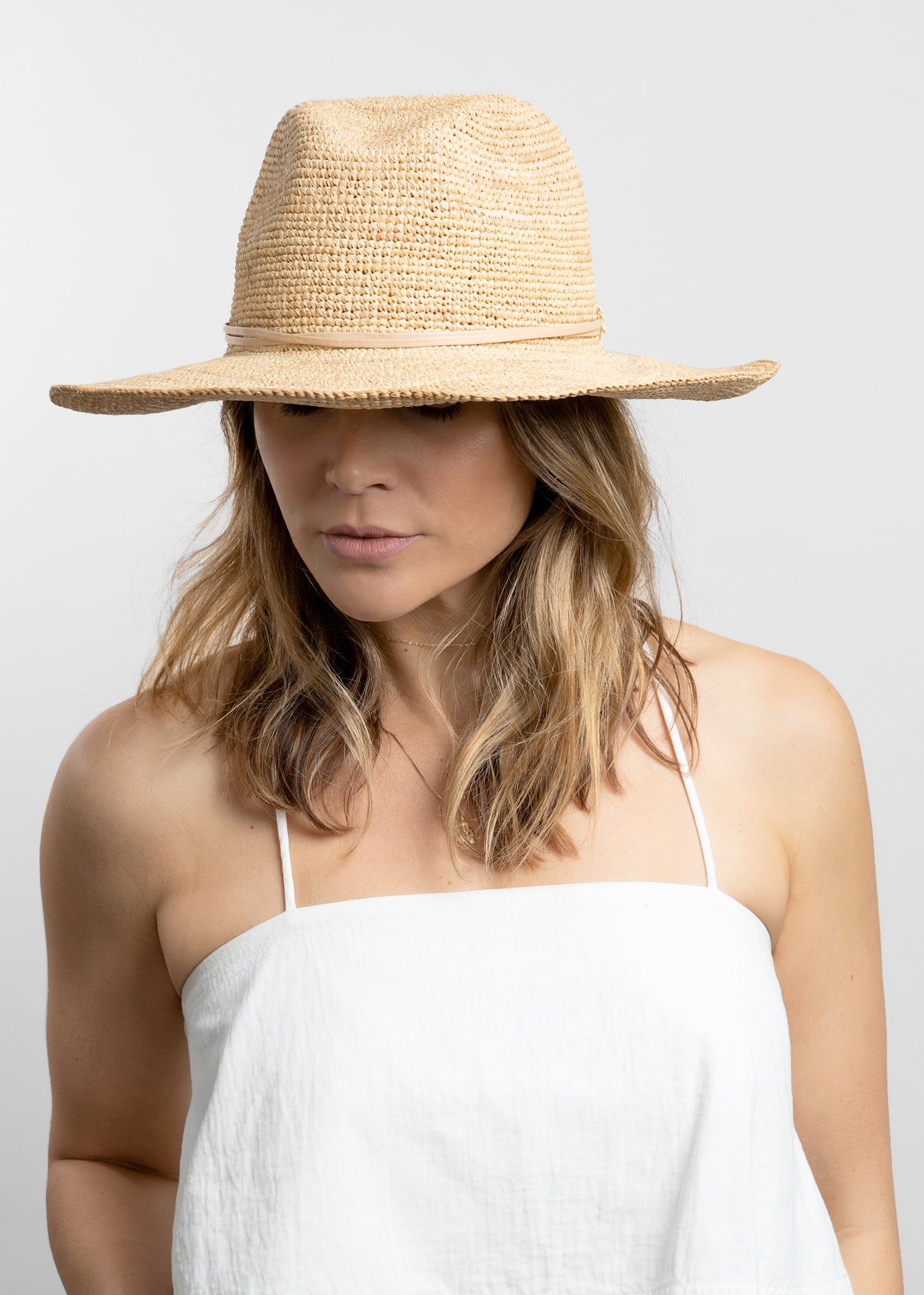 Model wearing crochet sunhat with tan wrap