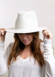 Model wearing white straw panama hat