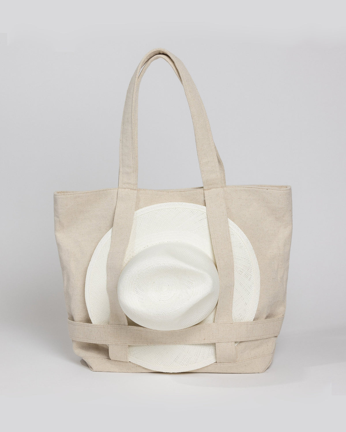 Tan canvas tote bag with white sun hat attached