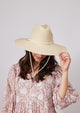 Model wearing surfer style sun hat and beach dress