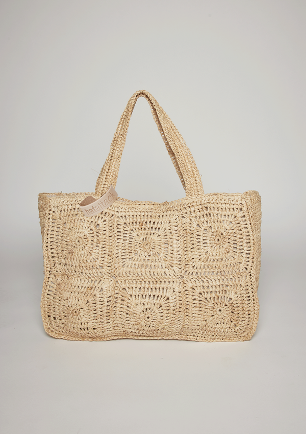 Straw tote with intricate design detail and hat loop