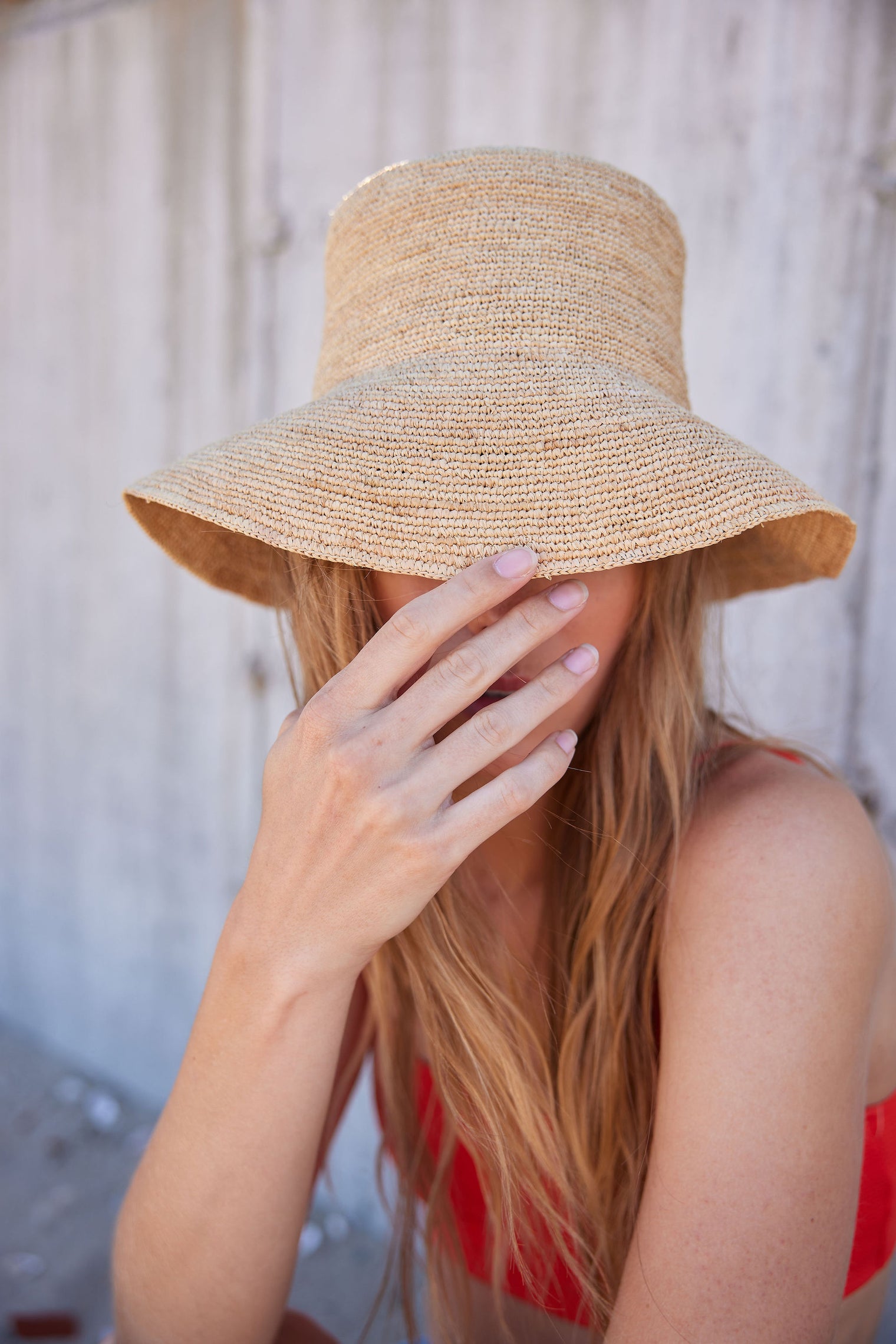 Model holding brim of straw bucket hat