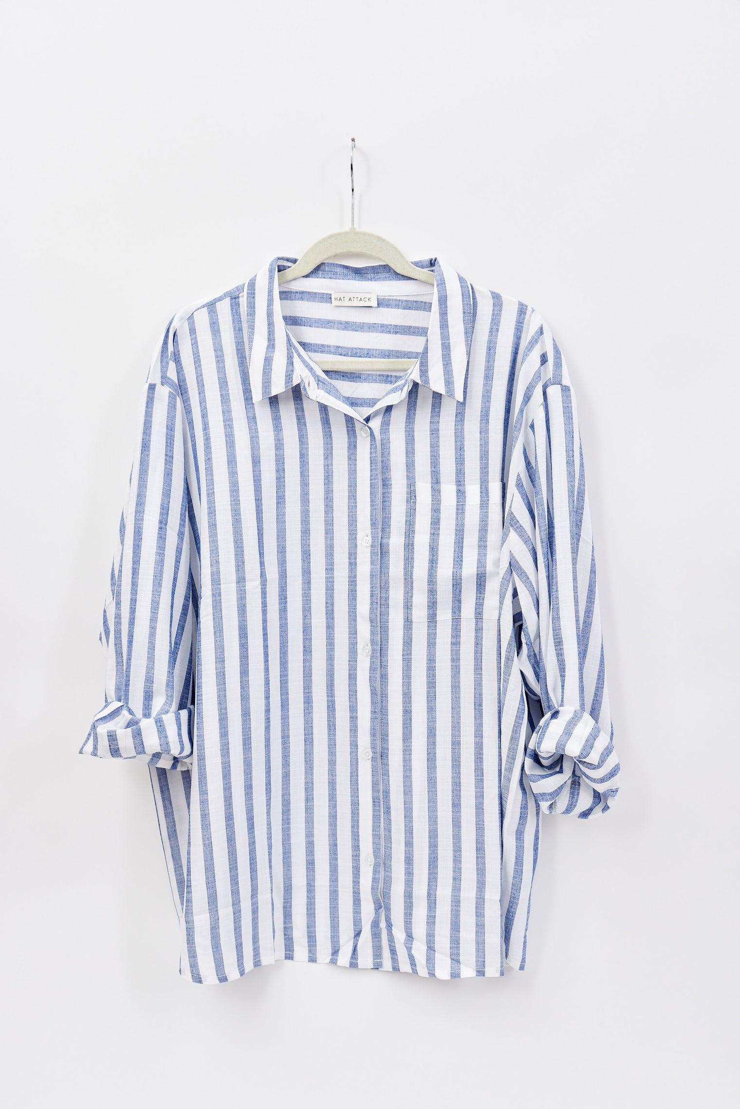 Blue and white striped shirt on a hanger against a white background