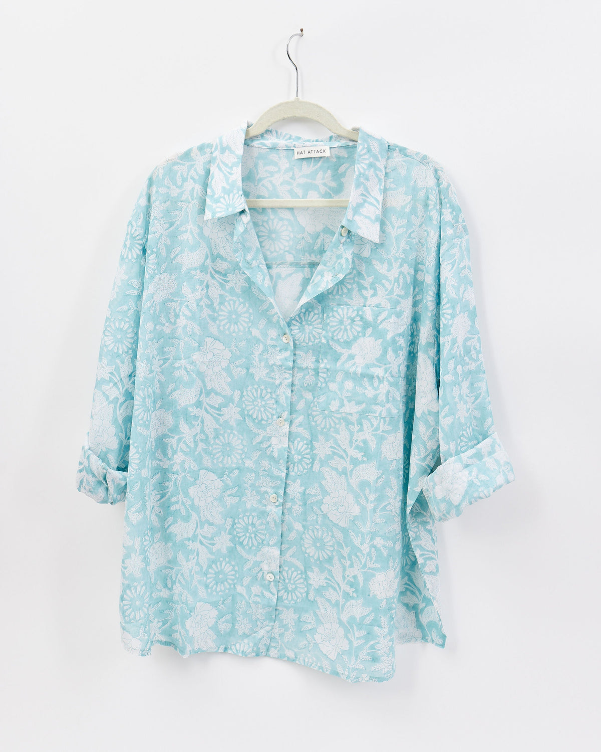 Light blue floral shirt on a hanger against a white background
