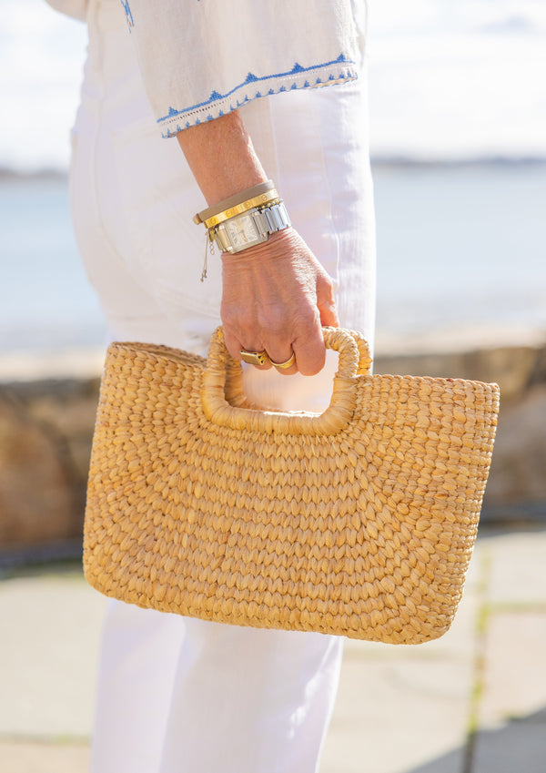 Model holding rectangular shape woven water hyacinth bag at beach