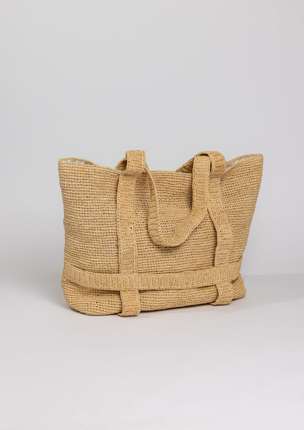 3/4 angle of Straw bag with straps that shows where a hat would be attached