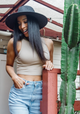 Molding wearing a black sun hat while standing next to a cactus