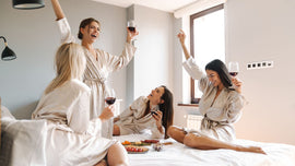 A joyful gathering of three friends  with glasses of wine in hand.