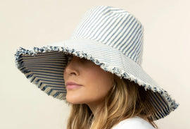 Woman wearing striped bucket hat and white T-shirt.