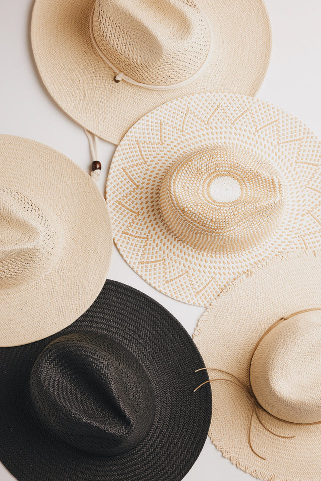Staw sun hats in different colors on white bacground.