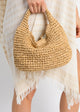 Model holding tan straw slouch bag
